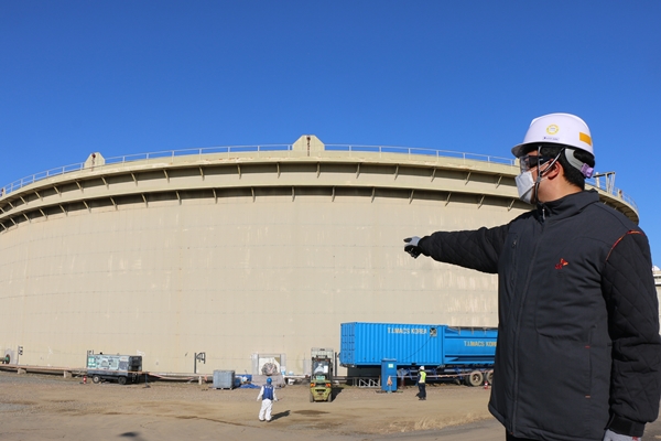 SK인천석유화학 엔지니어가 개방 검사 중인 원유 탱크 앞에서 새로 개발한 친환경 탱크 클리닝 기술을 설명하고 있다. (사진=SK인천석유화학)
